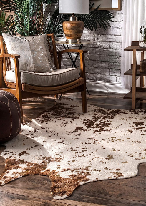 The brown faux cowhide rug placed in front of a living room chair