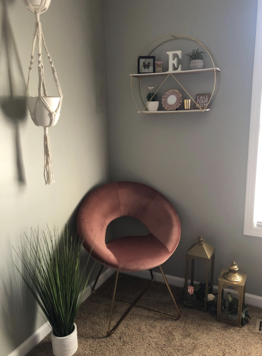A reviewer's pink accent chair in a room