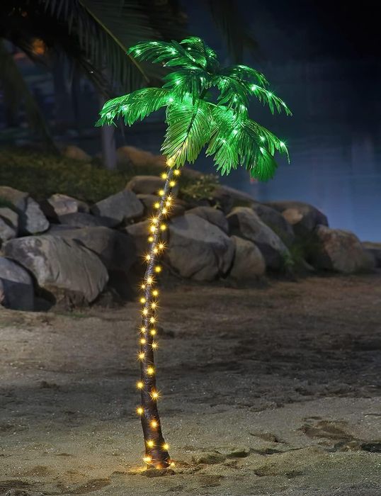 The glowing palm tree lit up at night.