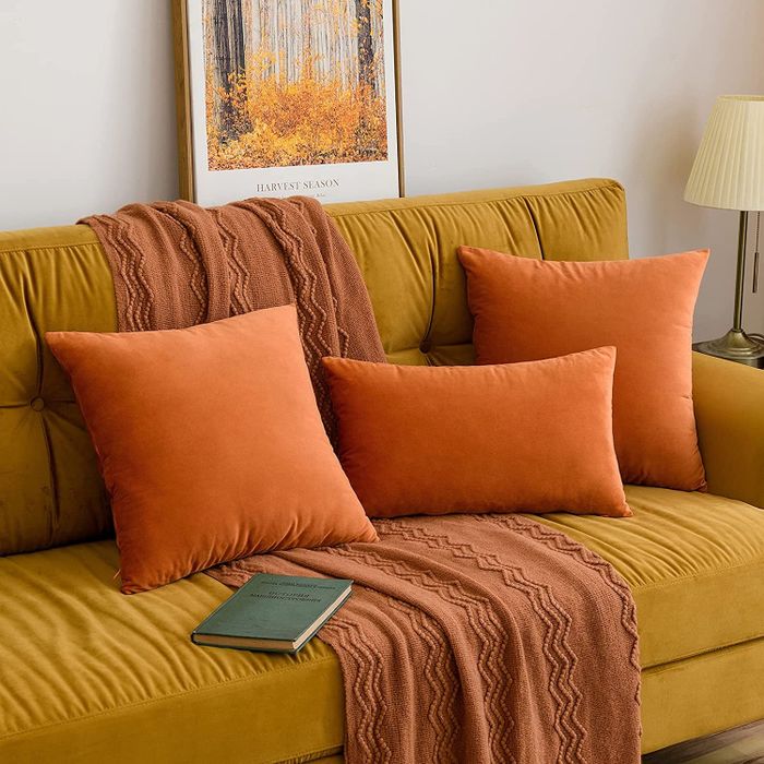 Rust orange pillows resting on a yellow couch