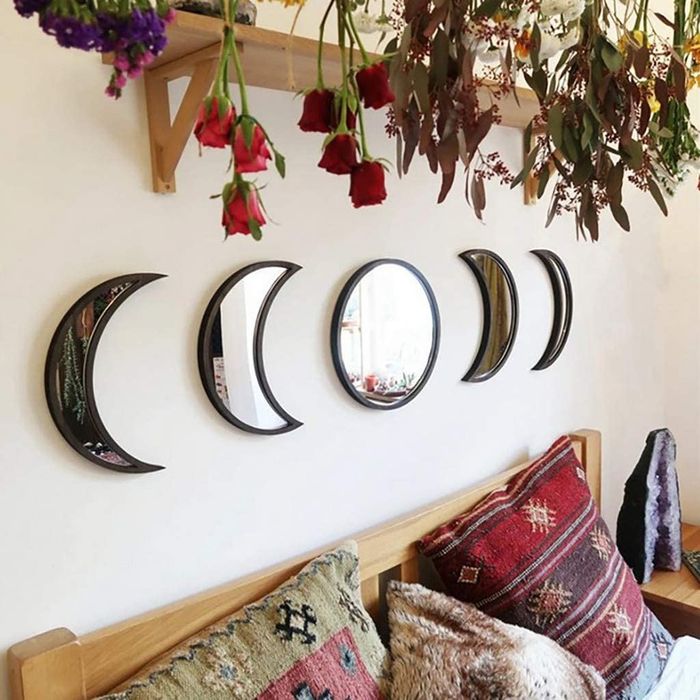 The five mirrors in black hanging above a bed