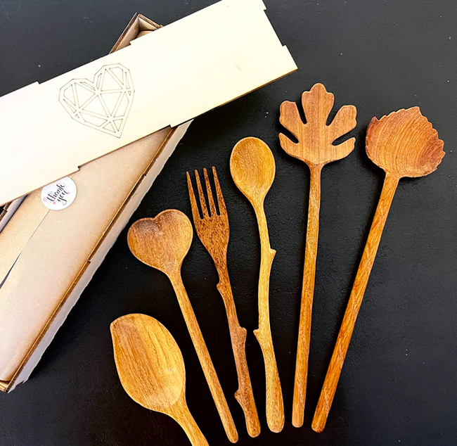 several wooden spoons placed next to their packaging in a reviewer's photo