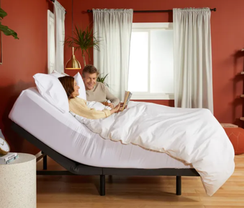 A couple lounging in an adjustable bed.