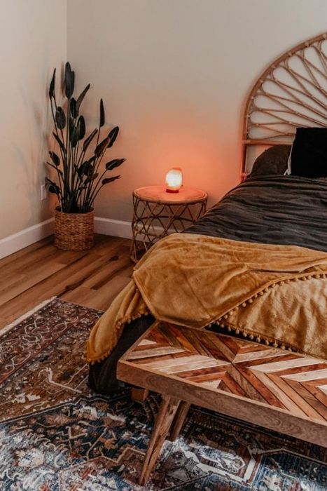 A reviewer displays the mustard yellow blanket draped across their bed.