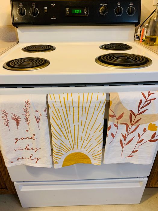 A reviewer shows the towels hanging on their oven.