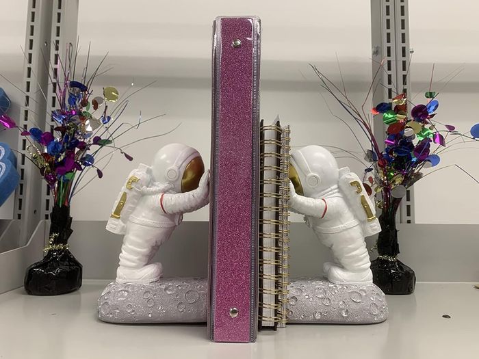 Two astronaut figurines supporting notebooks, as reviewed by customers.