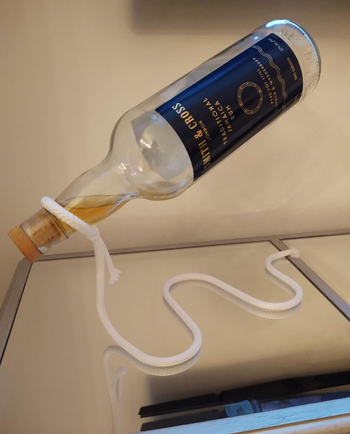 A bottle of vodka floating effortlessly on a holder.