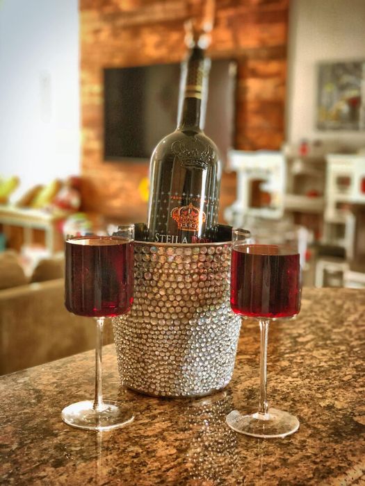 Another reviewer’s wine bottle placed in a sparkling ice bucket next to two filled wine glasses on the countertop