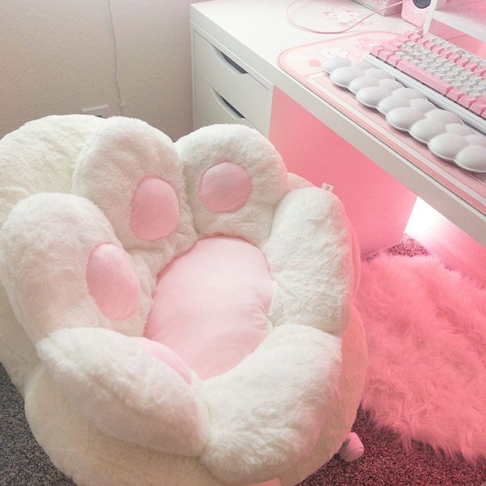 A plush paw-shaped pillow resting comfortably on a computer chair.