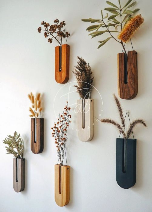 Seven different propagation vases hanging on a wall.