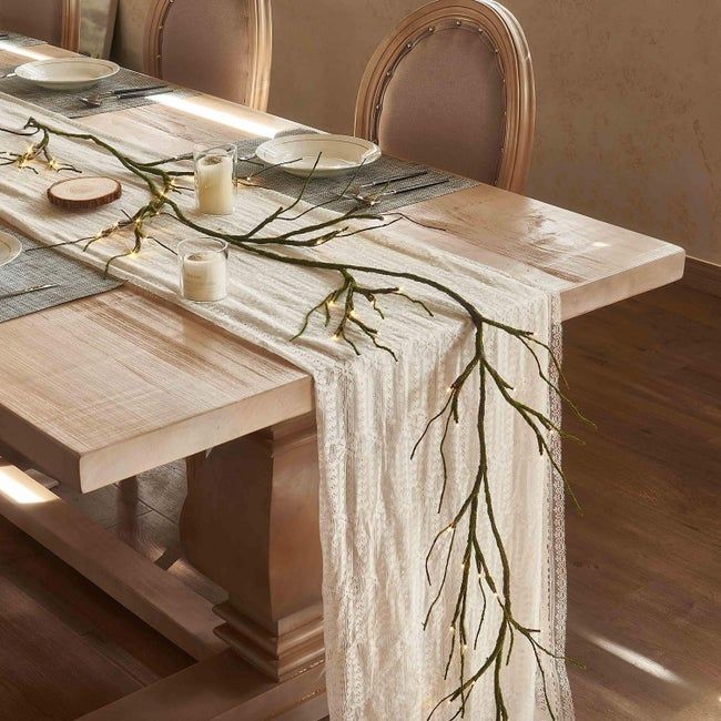 A branch with LED lights on the tips, used as a centerpiece on a table runner.