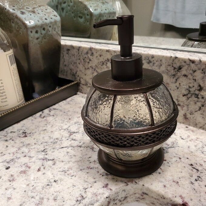the circular soap dispenser resting on a bathroom counter