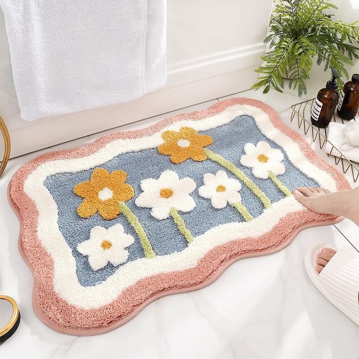 A bath mat featuring a beautiful flower pattern.