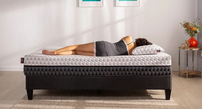 model sleeping peacefully on a black platform bed