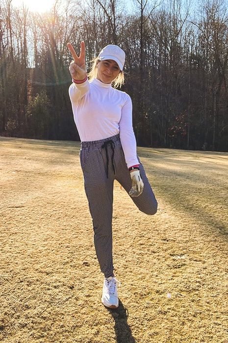 The reviewer is wearing a pair of black and white checked pants, adding a stylish touch to their outfit.