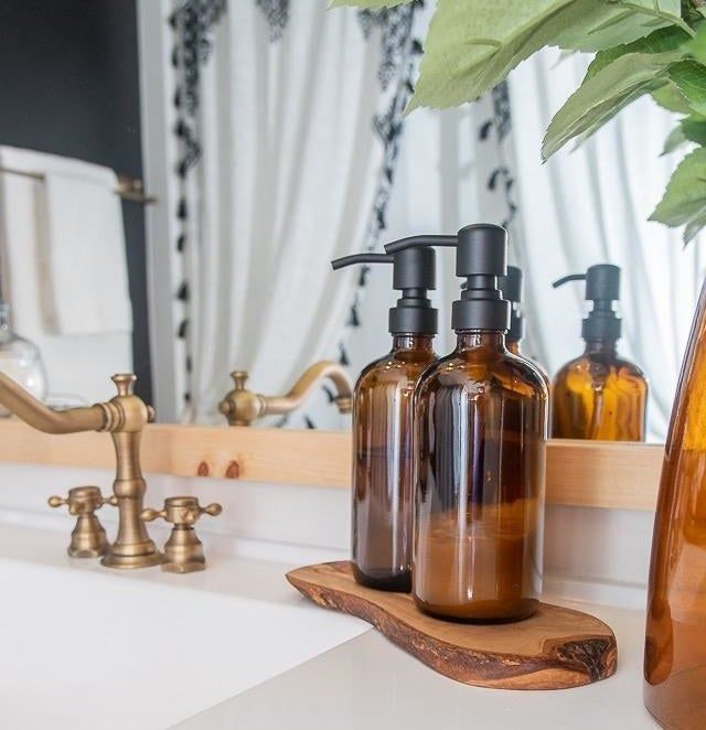Amber dispensers with black pumps resting on a bathroom countertop