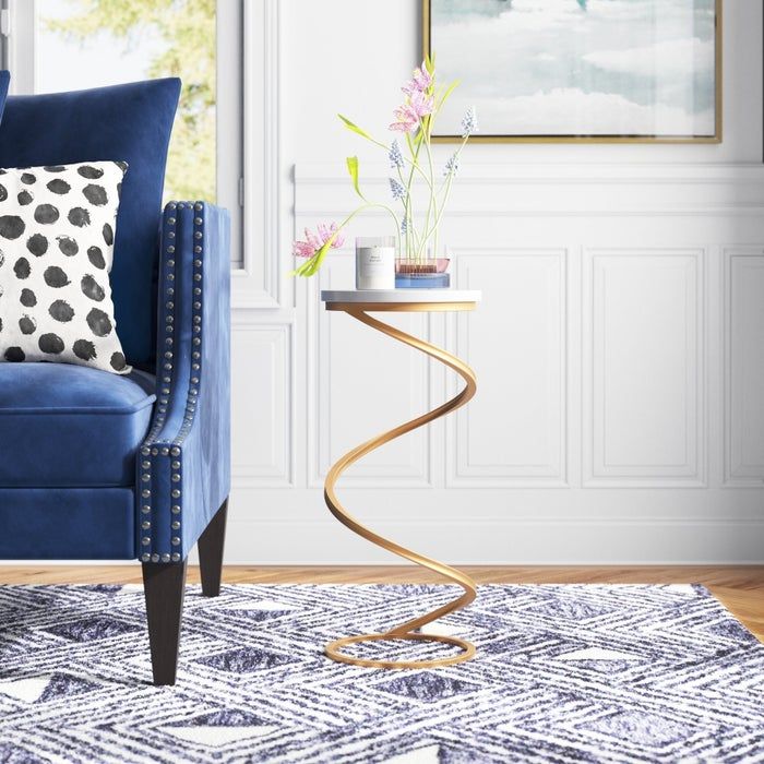 the end table featuring a marble top and a swirling base
