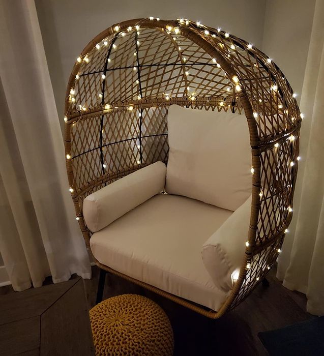 A reviewer photo of string lights wrapped around an egg chair