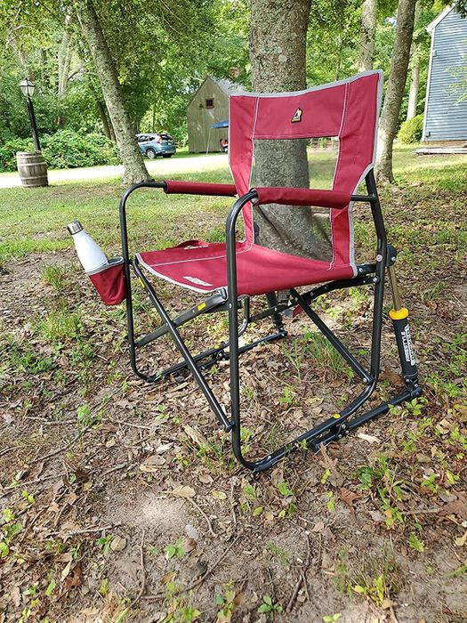 Reviewer image of a red outdoor rocking chair with a cup holder, sitting on grass