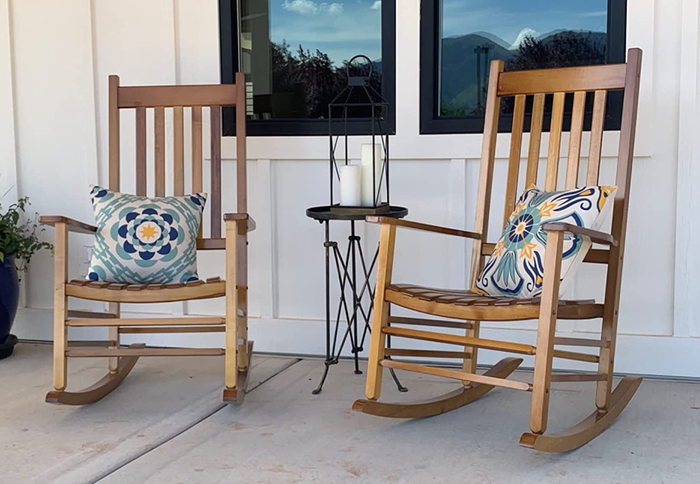 Reviewer image of two natural wooden rocking chairs with slatted backs, placed next to a side table with white candles