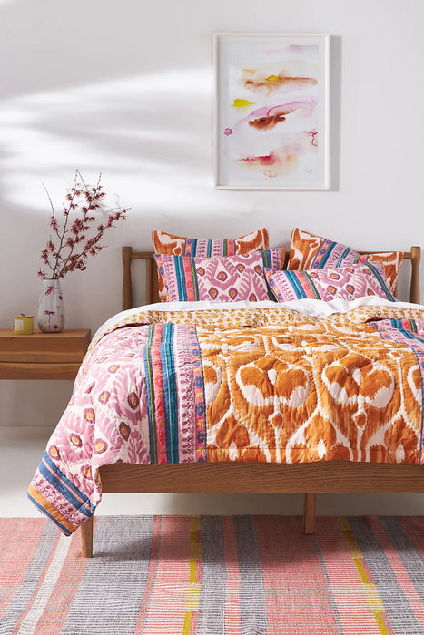 The reversible quilt laid across a bed.
