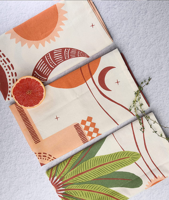 Three towels showcasing various orange and green designs.