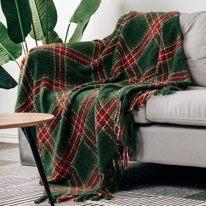 A red and green throw blanket draped over a couch.