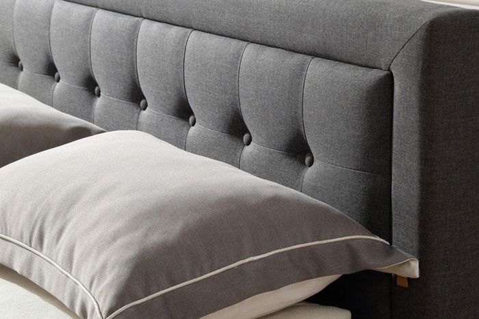 close-up view of a soft gray upholstered headboard