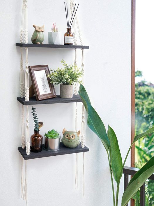 The three-tiered shelf displaying small plants, photos, and candles.