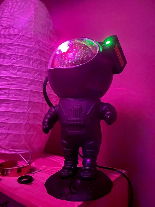 The astronaut-shaped figure with a projector in the visor of its helmet, casting celestial light.