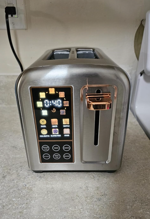 A modern toaster with digital controls and a range of settings for different types of bread, placed on a kitchen counter