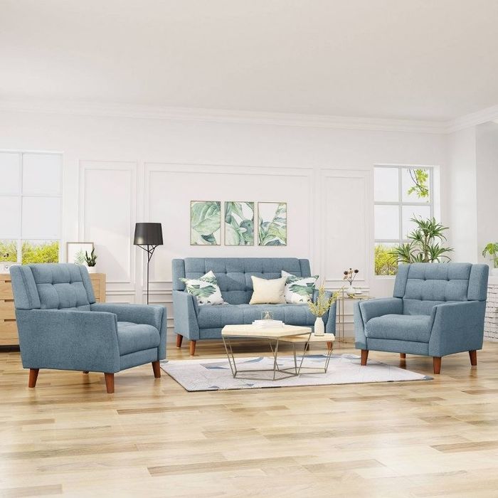 A three-piece blue living room set in a living room with wooden floors