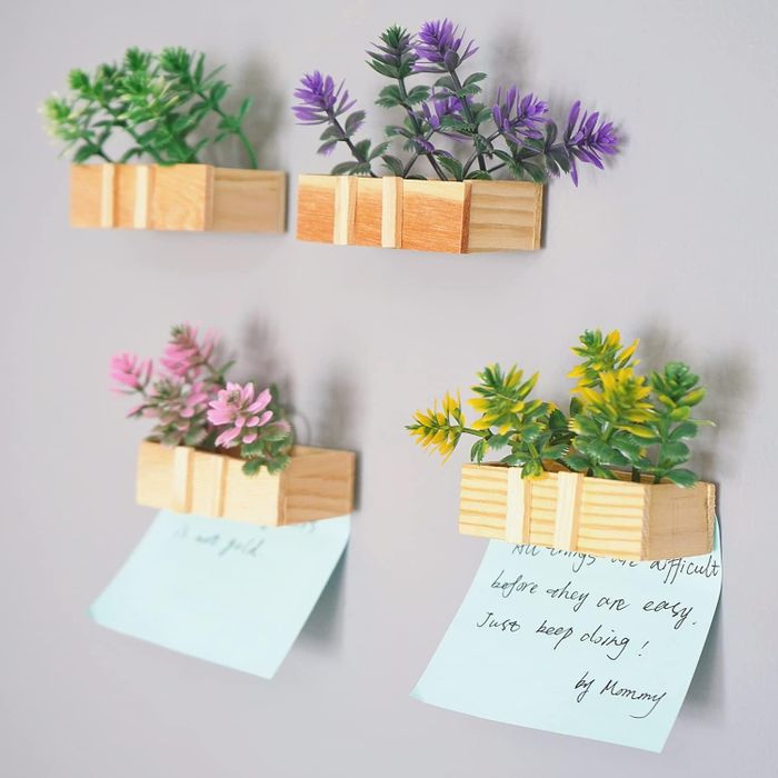 A set of four wood-mounted faux plants, some featuring motivational quotes, adding a lively touch to any home office decor.