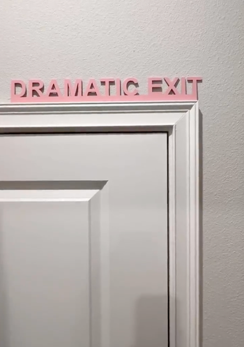 A sign hanging above a door reads