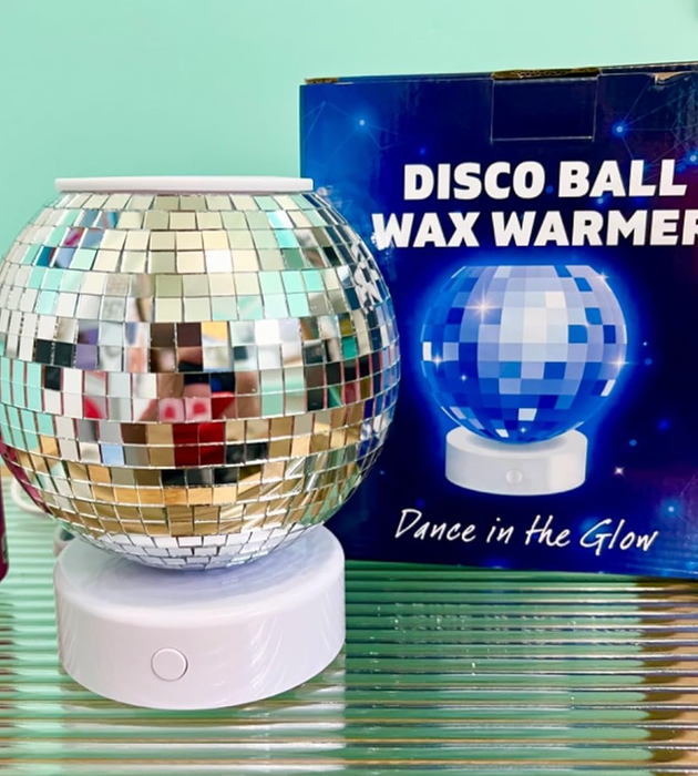 A disco ball-shaped wax warmer with a reflective surface, accompanied by its packaging that displays the product along with its tagline.