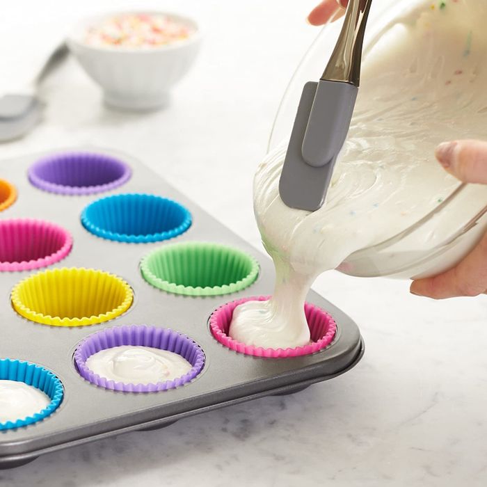 Cupcake liners in shades of pink, purple, yellow, green, and blue, arranged in a pan