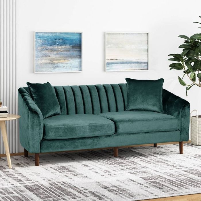 A teal velvet contemporary sofa elegantly placed in a living room