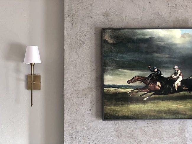 A reviewer's brass sconce elegantly mounted on the wall, adding a touch of style.