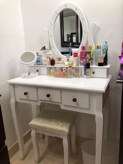 Reviewer photo of makeup and perfume neatly arranged on the vanity