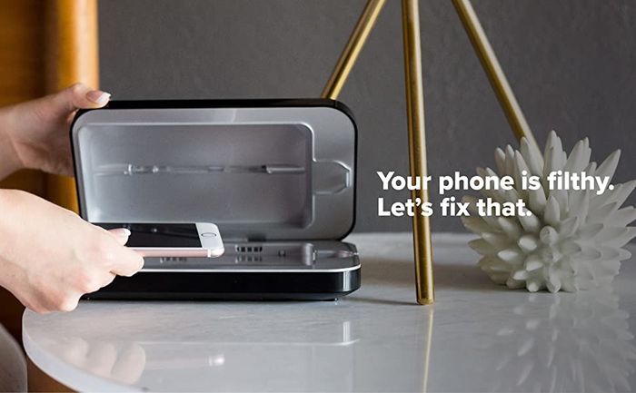 A phone being placed into the compact rectangular PhoneSoap device