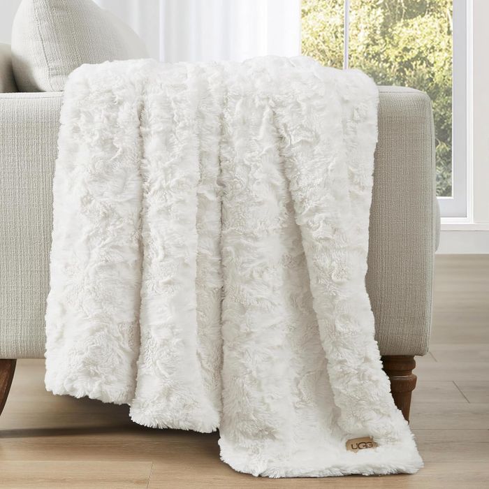 A luxurious faux fur throw cascading over a couch, adding both opulence and coziness to the home decor. Ideal for warmth and style.