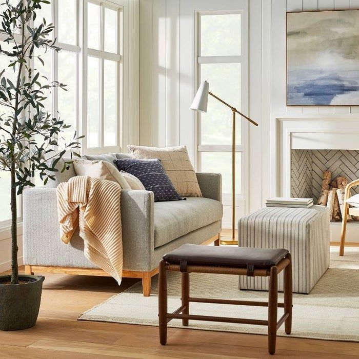 a light gray wood base sofa in a cozy living room