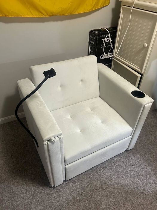White armchair with a built-in cup holder.