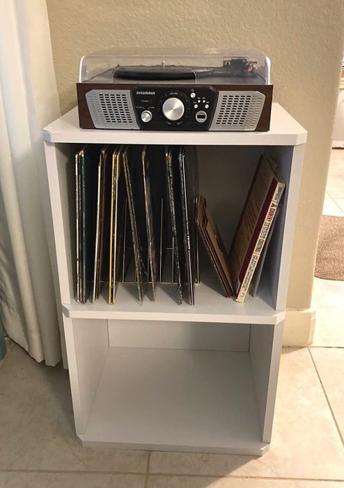 Reviewer image of a white cube shelf record player stand with a device placed on top and vinyls stored in the top shelf