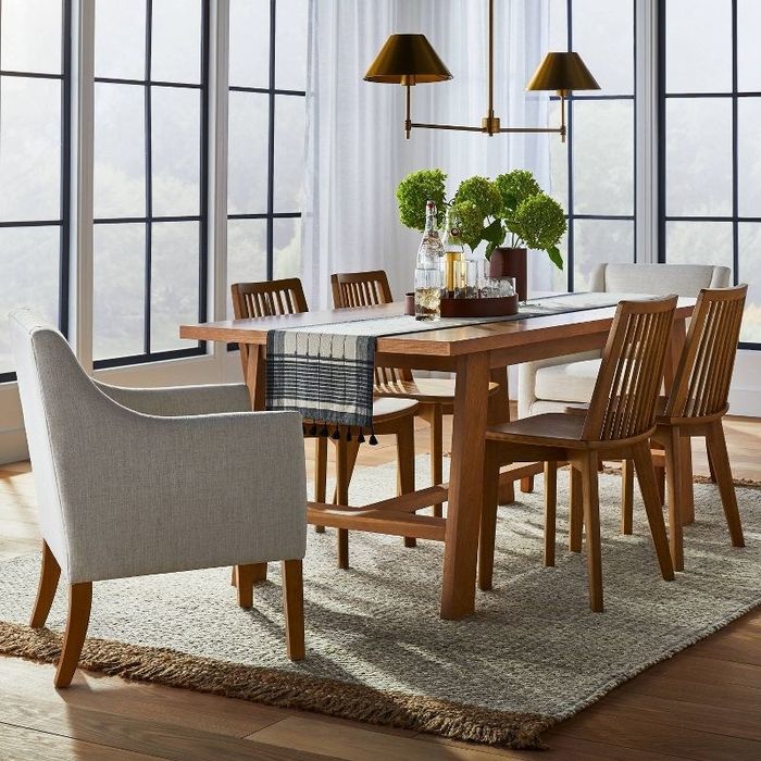 A cream-colored swoop-arm dining chair in a modern living room