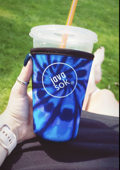 Reviewer holding an iced drink with a tie-dye blue Java Sok covering it from the bottom of the cup to the lid