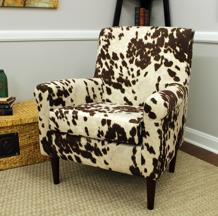 A cow print chair nestled in the corner of a room.