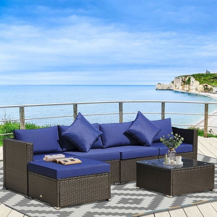 A six-piece navy blue rattan sofa set with a view of the coastline