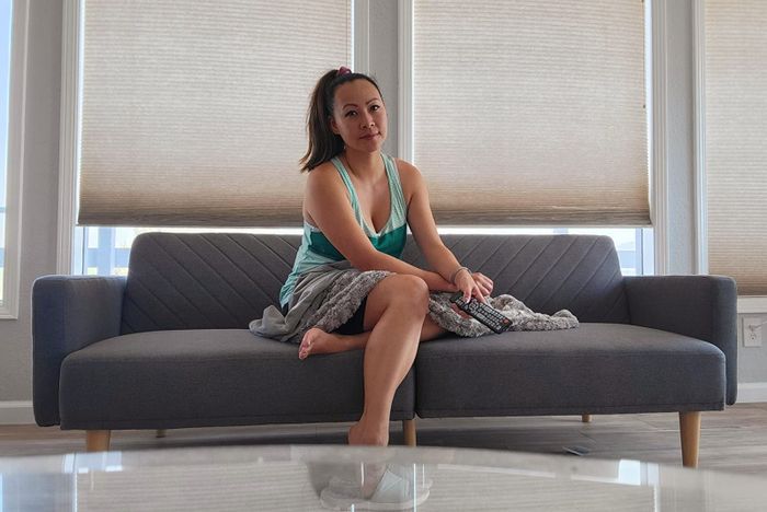 A reviewer relaxing on the gray sofa, showcasing its comfort and design.