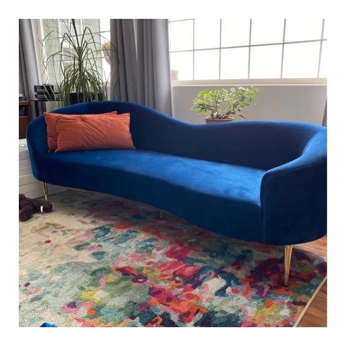 A reviewer photo of the blue sofa in a stylish living room setting